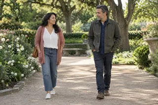 Two adults walking side by side along a garden path.