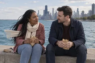 A couple eats homemade sandwiches beside Lake Michigan with the Chicago skyline behind them.
