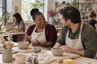 Two adults chat beside their clay bowls during a pottery workshop.